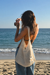 The Sunny Bag LOUNAILS écru porté en lifestyle plage au coucher du soleil